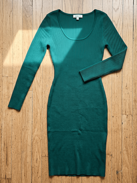 Flat-lay photo of a green ribbed dress on a wooden floor, ready to upload to ApparelAI Studio